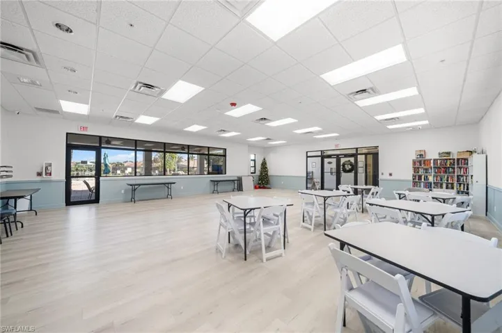 Dining area with a paneled ceiling and light wood-style flooring