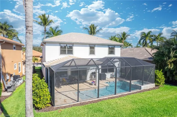 Back of house featuring a tiled roof, a lanai, and a sunroom