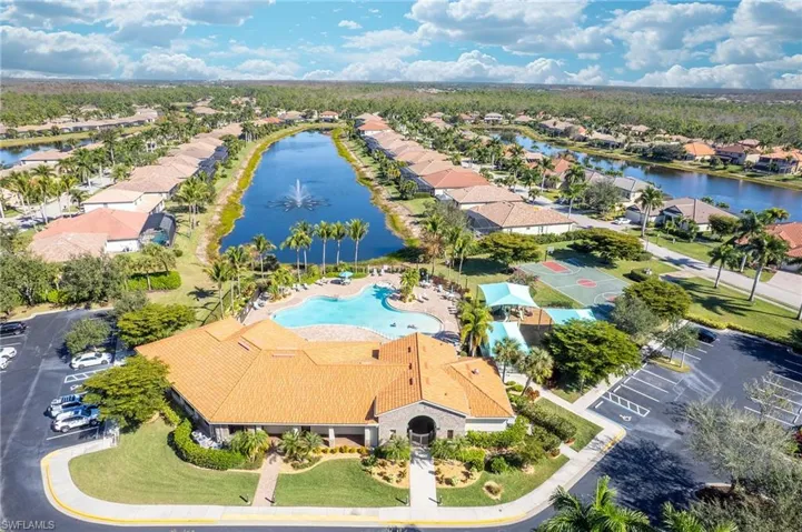 Aerial perspective of suburban area featuring a large body of water and a pool area