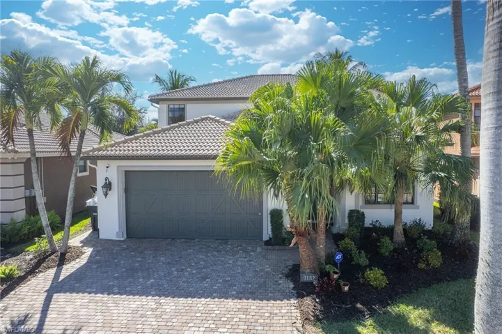 Mediterranean / spanish-style house with stucco siding, decorative driveway, a tile roof, and an attached garage