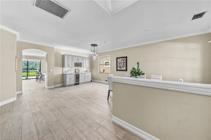 Entrance foyer featuring a chandelier, ornamental molding, and wood finish floors