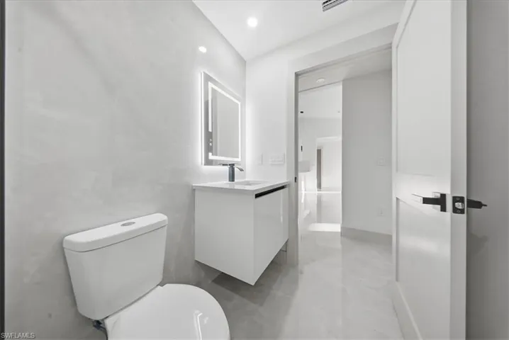 Half bath featuring vanity and recessed lighting