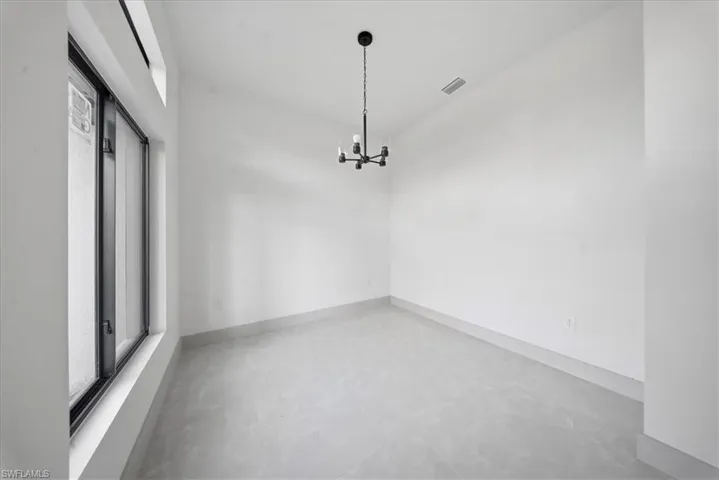 Unfurnished dining area with finished concrete flooring and hanging lights