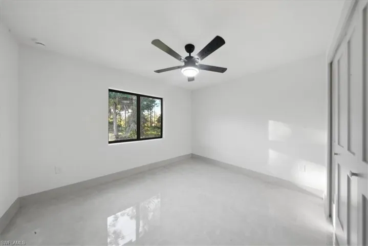 Unfurnished room with concrete flooring and ceiling fan