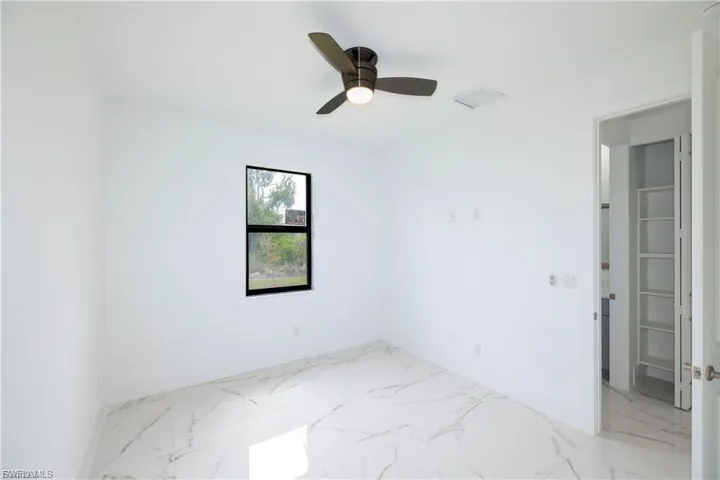 Empty room with light marble finish flooring and ceiling fan