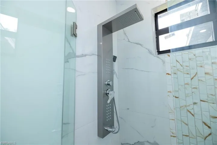 Full bath featuring a marble finish shower