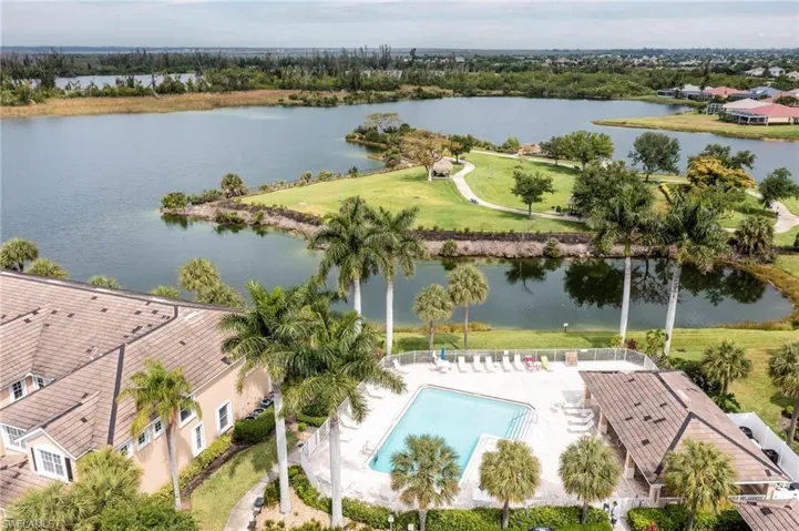Aerial view of a pool area and a large body of water