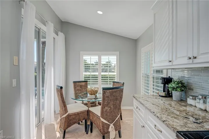Dining area with lofted ceiling, light tile patterned floors, and recessed lighting