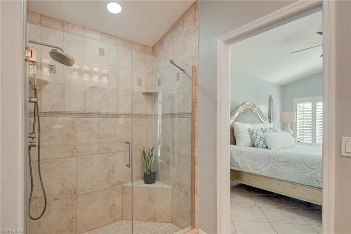 Ensuite bathroom featuring a stall shower, tile patterned floors, vaulted ceiling, recessed lighting, and a ceiling fan