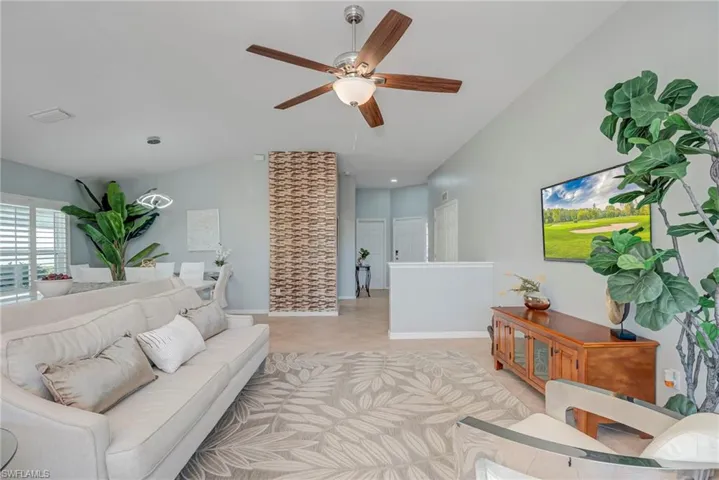 Living area featuring ceiling fan and lofted ceiling