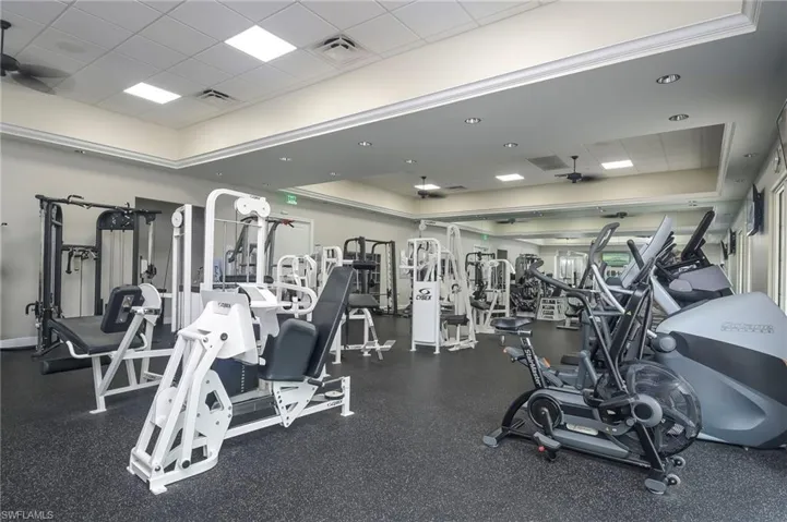 Gym featuring a ceiling fan and a paneled ceiling