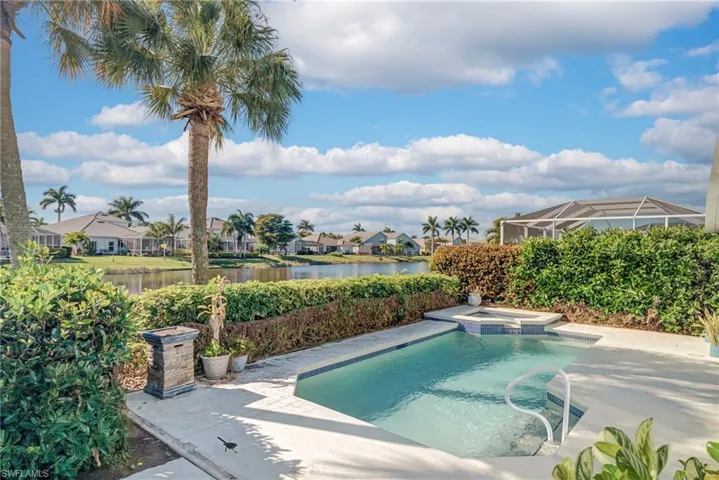 View of swimming pool with a residential view, a pool with connected hot tub, a patio, and a water view