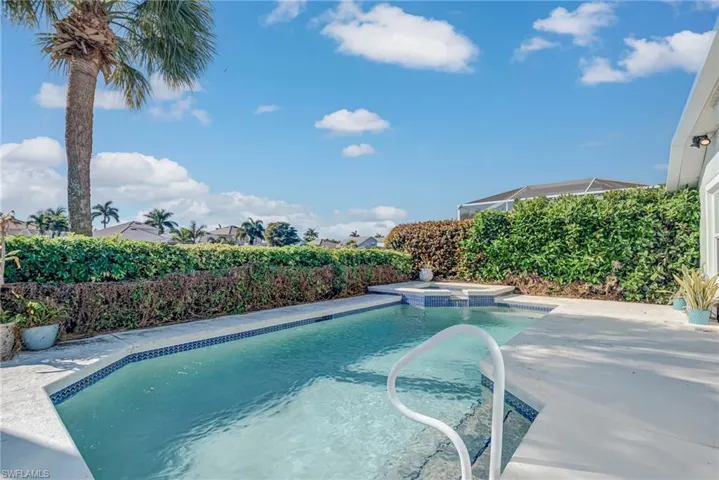 View of pool featuring a patio, a pool with connected hot tub, and a fenced backyard