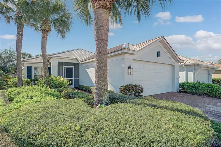 View of front of property with stucco siding, decorative driveway, a metal roof, and a garage