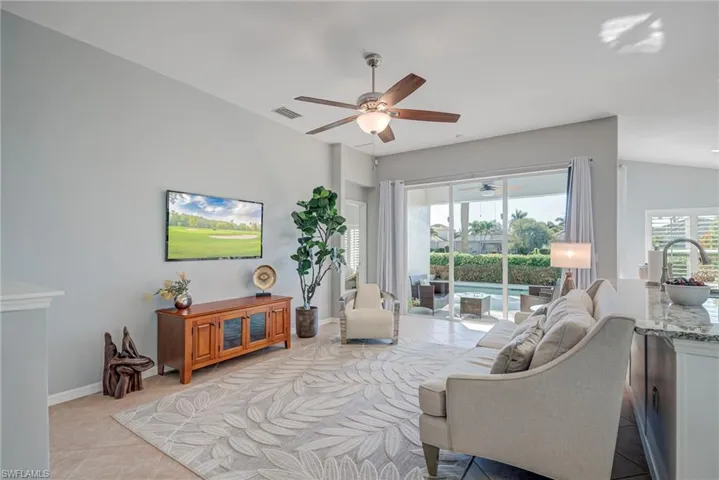 Living room with light tile patterned floors and a ceiling fan
