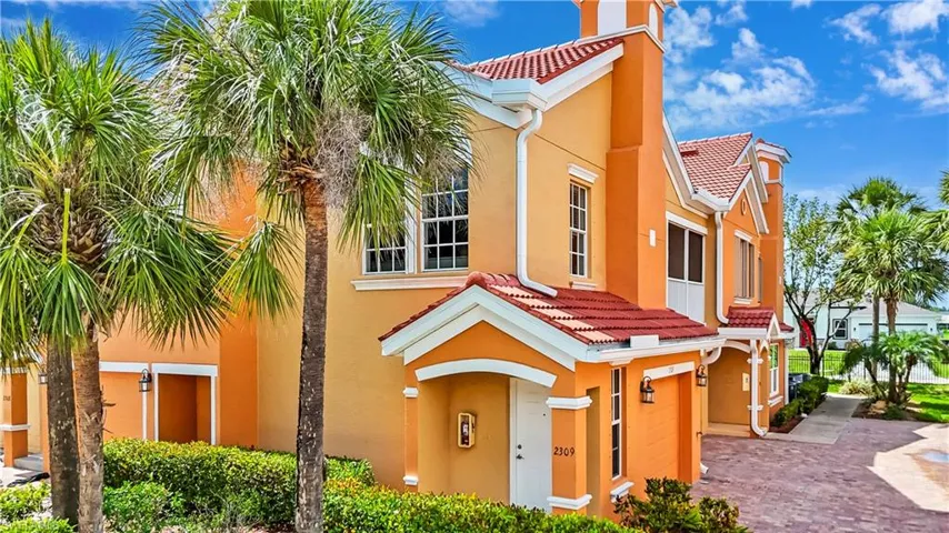 View of front of property featuring a tiled roof, an attached garage, stucco siding, and driveway