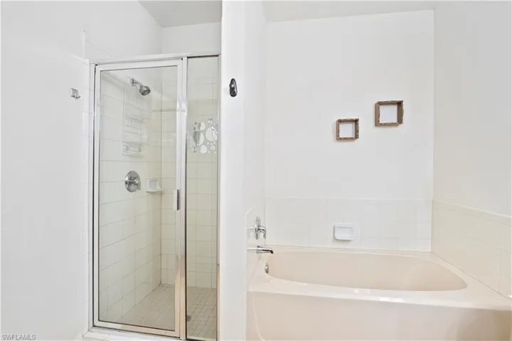 Full bath featuring a garden tub and a shower stall