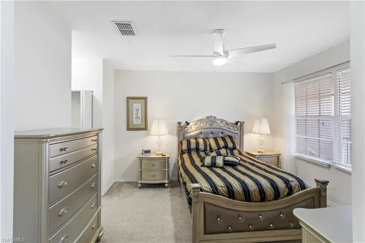 Carpeted bedroom with baseboards and a ceiling fan