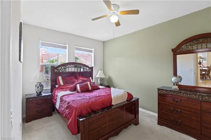 Bedroom with light carpet and a ceiling fan
