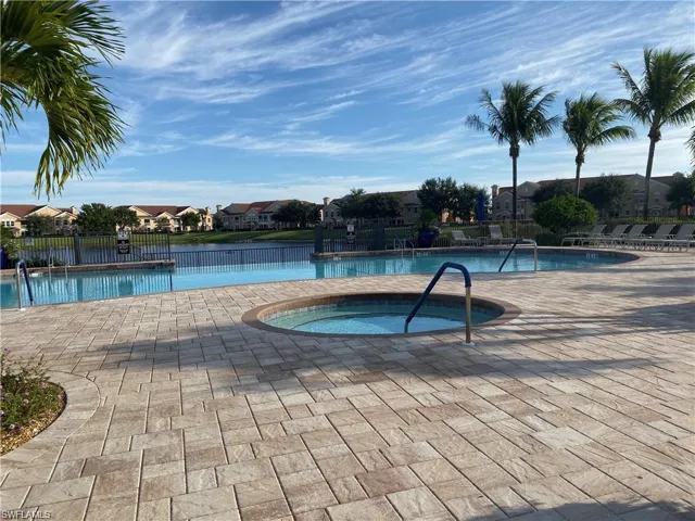 Community pool with a community hot tub, a patio area, and a residential view