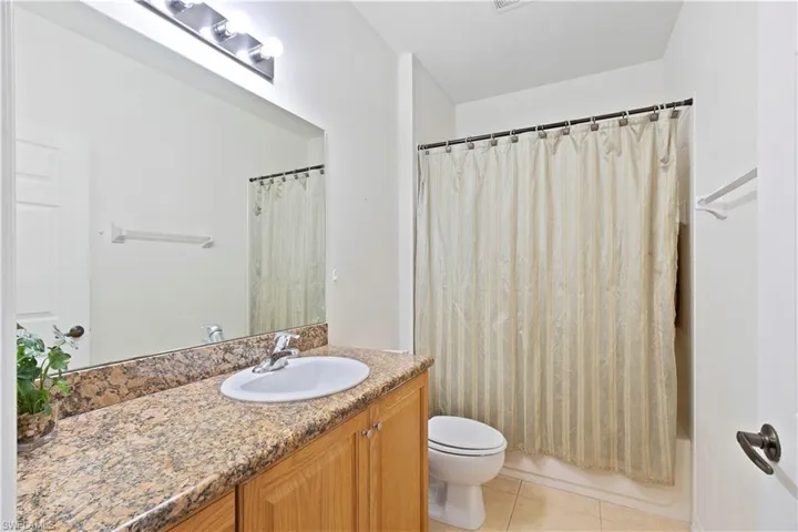 Bathroom featuring vanity, tile patterned floors, and shower / bath combination with curtain