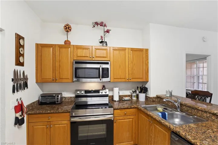 Kitchen with appliances with stainless steel finishes and brown cabinets