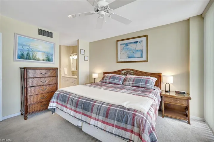 Carpeted bedroom with baseboards, a ceiling fan, and connected bathroom
