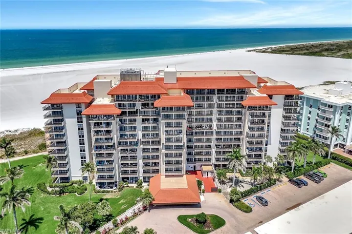 View of apartment building / complex featuring view of water and beach