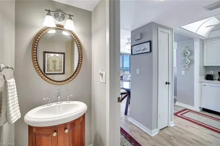 Bathroom with wood finished floors, vanity, and baseboards