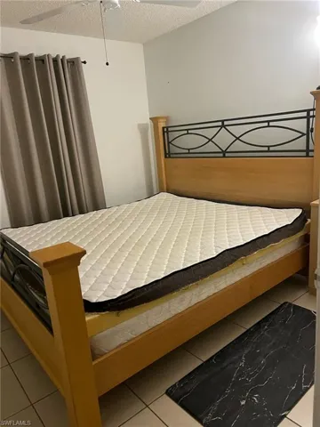 Bedroom with tile patterned floors and a textured ceiling