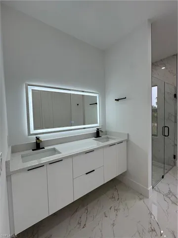 Bathroom featuring vanity and a shower with shower door