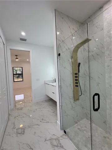 Bathroom featuring a shower with door and vanity