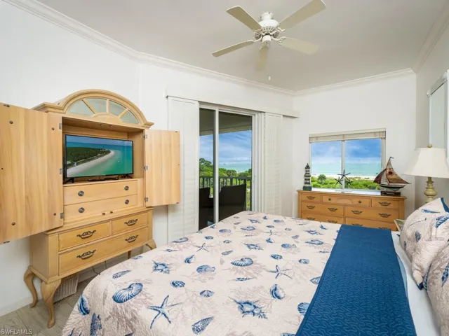 Bedroom with ornamental molding, access to outside, and a ceiling fan