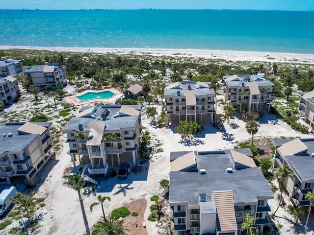 Drone / aerial view of unending shoreline and a pool area