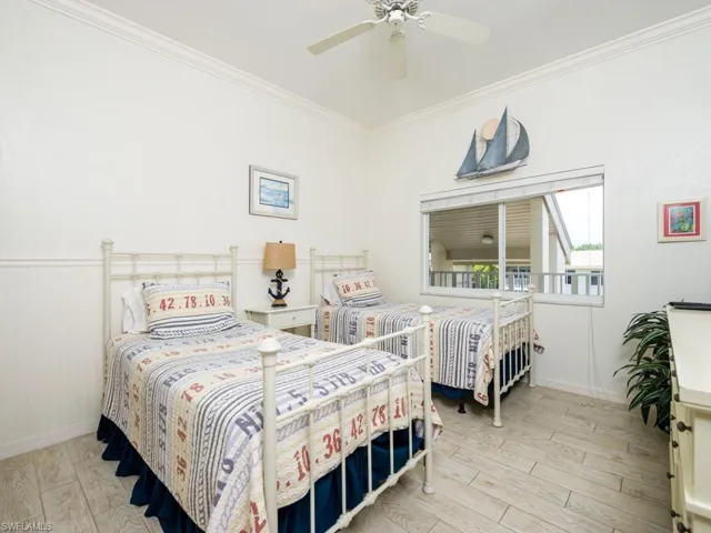 Bedroom with ornamental molding, light wood finished floors, and ceiling fan
