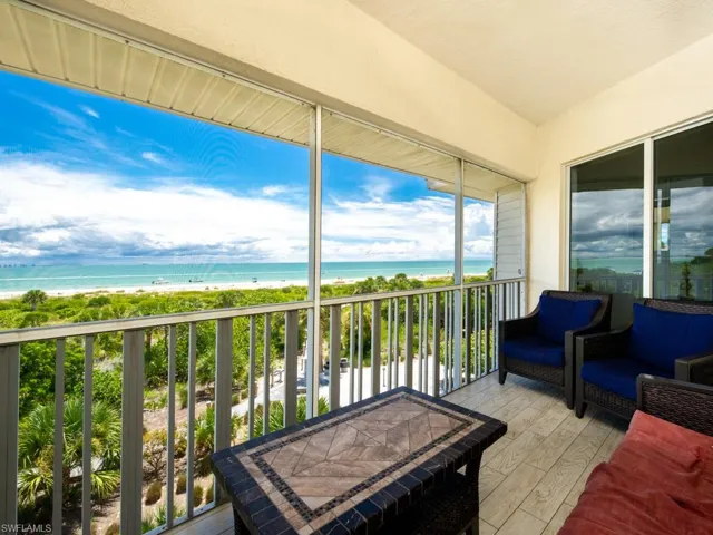 Sunroom / solarium featuring view of water and beach
