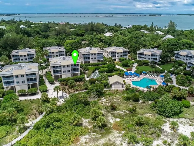 Drone / aerial view of a nearby body of water and a pool
