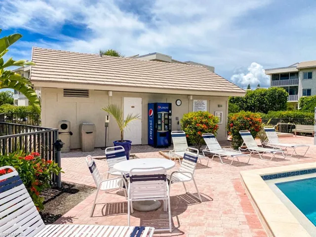 Back of house featuring stucco siding, a community pool, and a patio