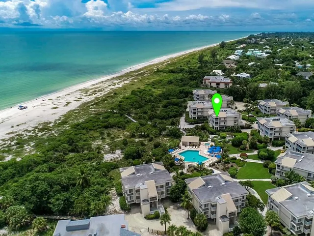 Bird's eye view of waterfront with a beach and a pool area