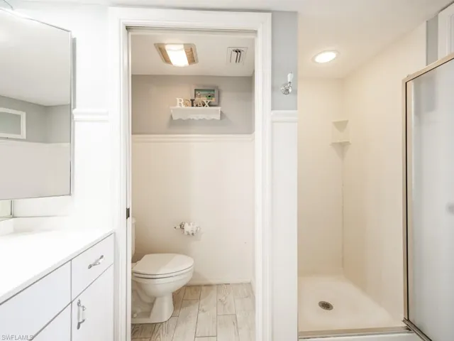 Bathroom with vanity, a stall shower, and light wood-type flooring