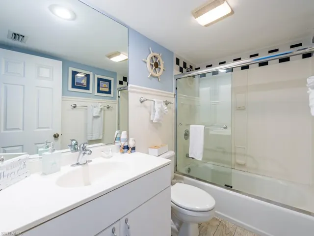 Full bath featuring enclosed tub / shower combo and vanity