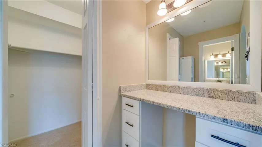 Bathroom with vanity and walk-in closet
