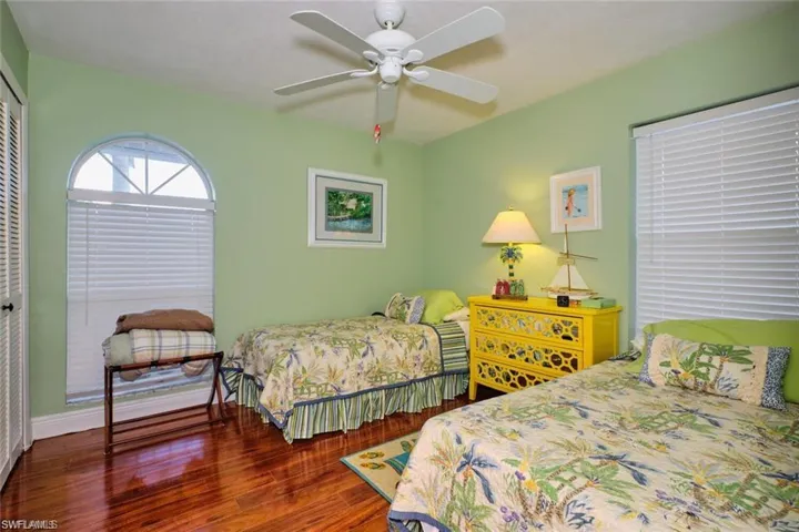 Bedroom featuring ceiling fan, wood-type flooring, and a closet