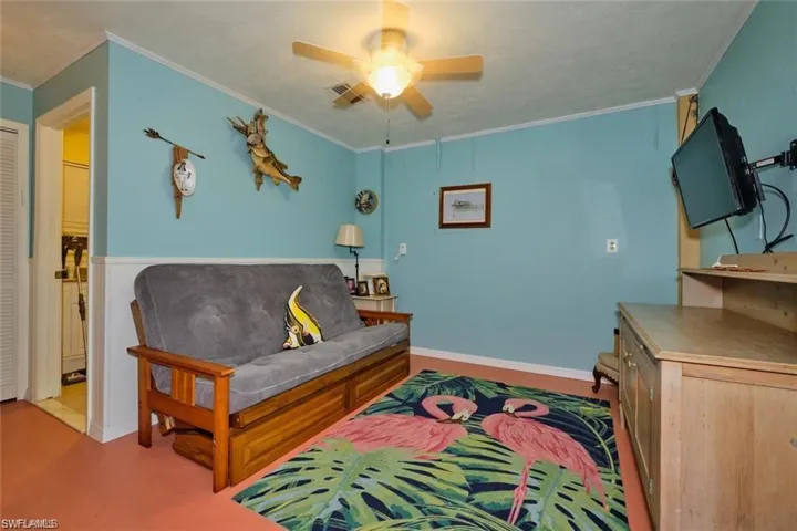 Living room with crown molding and ceiling fan