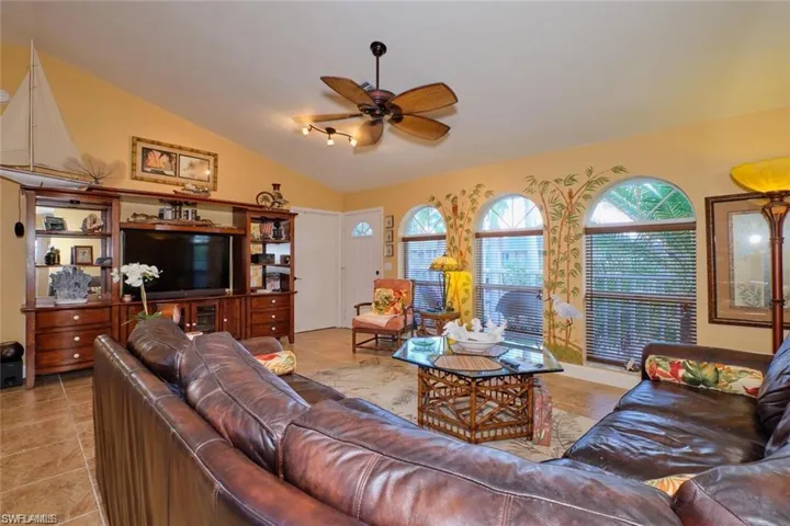 Living room featuring tile patterned floors, lofted ceiling, and ceiling fan