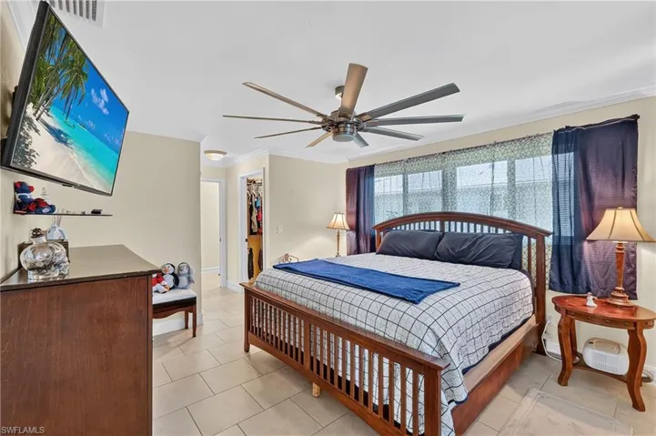 Recessed lighting, crown molding, and a ceiling fan with multiple blades
