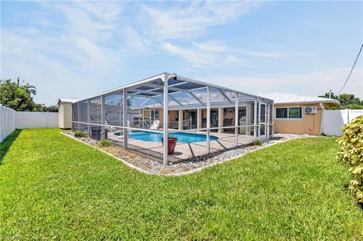 Screened-in pool enclosure featuring a swimming pool, concrete patio, and decorative gravel