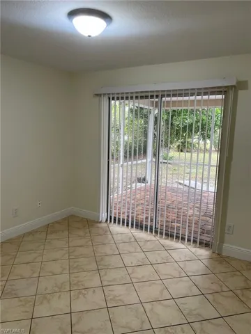 Spare room with baseboards, a healthy amount of sunlight, and tile patterned flooring