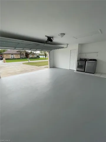 Garage with a garage door opener and washer and clothes dryer