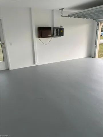 Garage with electric panel and an AC wall unit